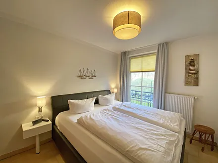 Schlafzimmer mit Echtleder-Doppelbett in Komforthöhe (2 x 0,90 m x 2,00 m), mit Nachttischablagen, Insektenschutzgittern, Verdunklungsmöglichkeit und einen großem Kleiderschrank