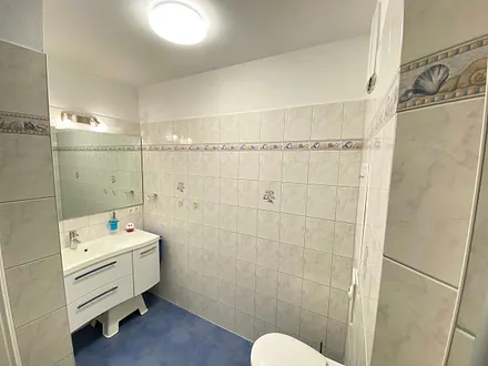 innenliegendes Badezimmer mit Waschtisch, ebenerdiger Dusche, Fön, Kosmetikspiegel, WC und beheizbaren Handtuch-Heizkörper