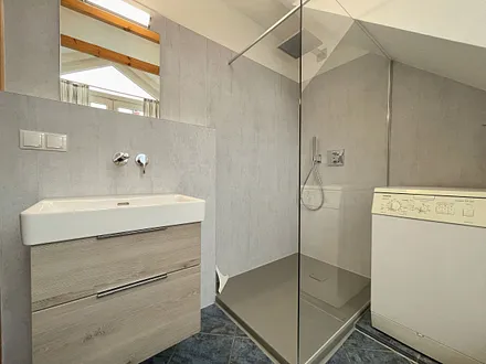 Badezimmer mit Dusche, WC, Fön, Waschmaschine (Münzgerät) sowie Fußbodenheizung und Handtuchtrockner