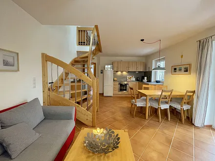 Wohnzimmer mit gemütlicher Couchecke, Couchtisch und Leselampe sowie ein Smart-TV und ein DAB-Radio mit CD-Player