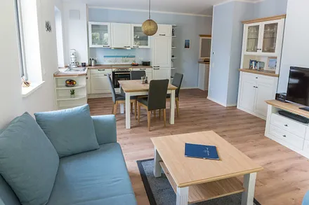 offener Wohnbereich mit bequemer Couch (Aufbettung 3. Person 1,60 m x 2,00 m), Sessel, Couchtisch, Stehlampe, Sideboard, Vitrine, Smart-TV sowie ein DAB Radio mit Bluetooth