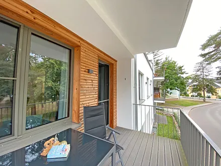 überdachter Balkon (Nord) mit Sitzgarnitur und Blick auf den Park