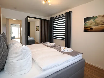 Schlafzimmer mit Boxspringbett und Verdunkelungsmöglichkeiten