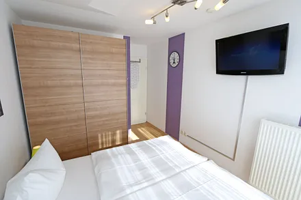 Schlafzimmer mit Doppelbett und TV