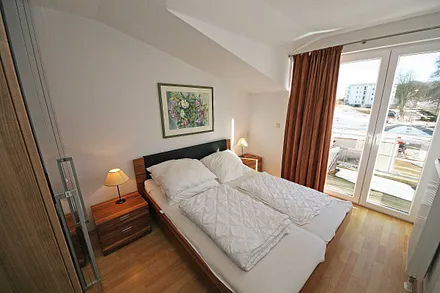 Schlafzimmer mit Doppelbett, Nachttischkonsolen und einen großen Kleiderschrank