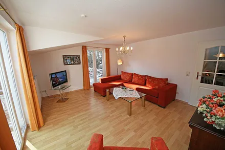 gemütliches Wohnzimmer mit Eckcouch (Aufbettung für die 3. Person), Sessel, Flachbild TV, Couchtisch sowie eine Anrichte