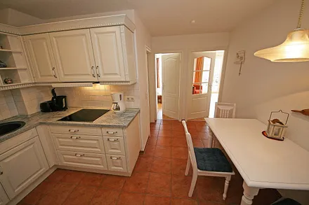 offene Küchenzeile mit Ceranfeld, Backofen, Geschirrspüler, Kühlschrank, Kaffeemaschine, Wasserkocher, Toaster sowie diverse Küchenutensilien