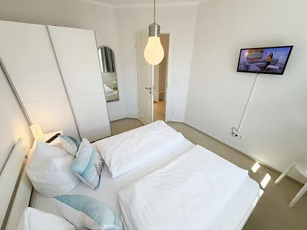 Schlafzimmer mit Doppelbett und Smart-TV