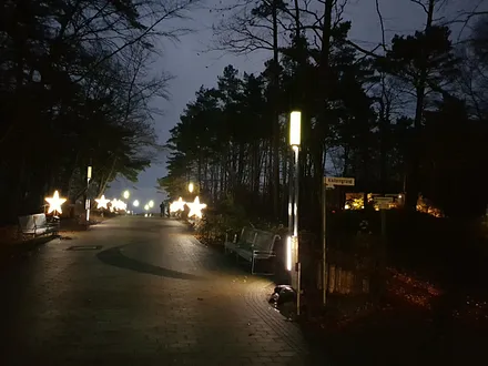 Blick auf das beleuchtete Haus (rechts oben) und die weihnachtlich dekorierte Kurpromenade
