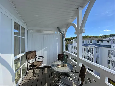 bestuhlter Balkon mit Sonnenliegen