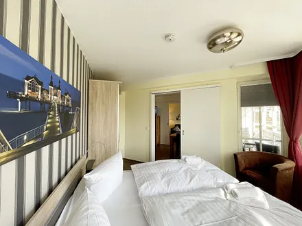 Schlafzimmer mit Doppelbett, Sessel und Kleiderschrank