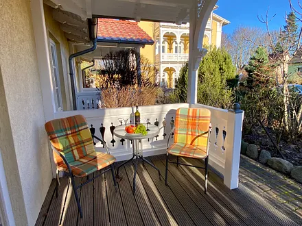 Eingang mit Holzveranda und Sitzgelegenheit