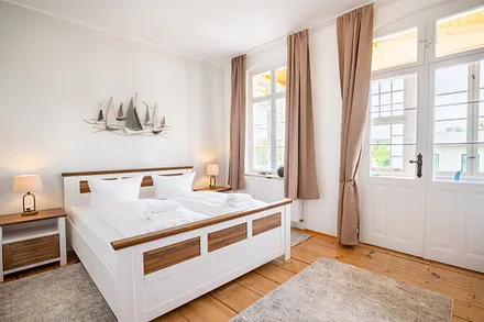 1. Schlafzimmer mit Doppelbett und angrenzendem Wintergarten