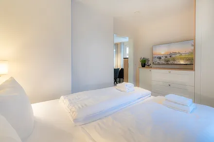 Schlafzimmer mit Doppelbett und TV