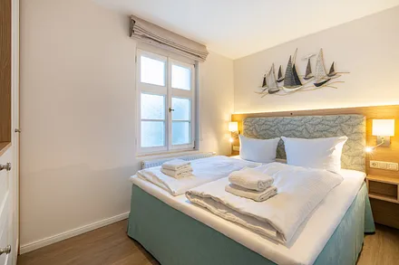 Schlafzimmer mit Doppelbett und TV