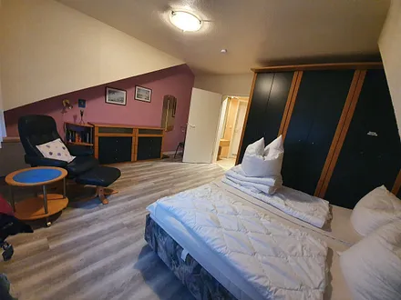 Schlafzimmer mit Doppelbett und Relaxsessel