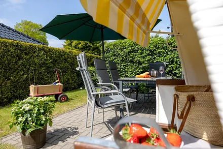 Große Sonnenterrasse mit Gartenmöbel und Strandkorb 