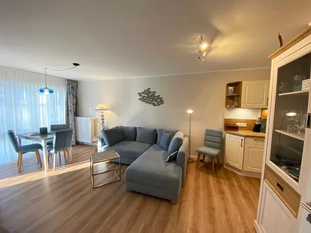 Wohn-/ Essbereich mit gemütlicher Couch (Aufbettung 3. Person, Liegefläche 1,60 m x 2,00 m), Couchtisch, Leselampe, Lowboard mit Smart-TV und einem DAB Radio mit USB-Anschluss und Bluetooth Anschluss 