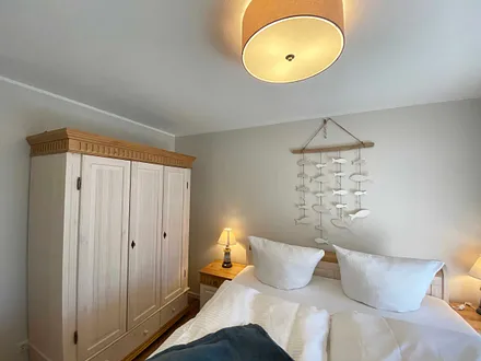 Schlafzimmer mit Doppelbett (1,80 m x 2,00 m), Nachttischablagen mit Lampen und einen Kleiderschrank