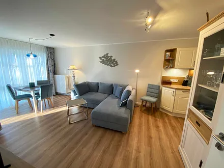 Wohn-/ Essbereich mit gemütlicher Couch (Aufbettung 3. Person, Liegefläche 1,60 m x 2,00 m), Couchtisch, Leselampe, Lowboard mit Smart-TV und einem DAB Radio mit USB-Anschluss und Bluetooth Anschluss 