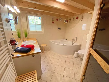 Badezimmer mit Dusche, Sauna, Whirlpool, Waschplatz, WC, Fön, Waschmaschine und Trockner 