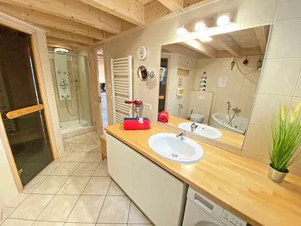 Badezimmer mit Dusche, Sauna, Whirlpool, Waschplatz, WC, Fön, Waschmaschine und Trockner 