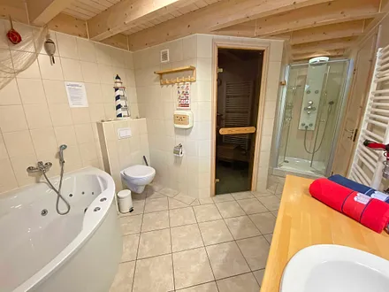 Badezimmer mit Dusche, Sauna, Whirlpool, Waschplatz, WC, Fön, Waschmaschine und Trockner 