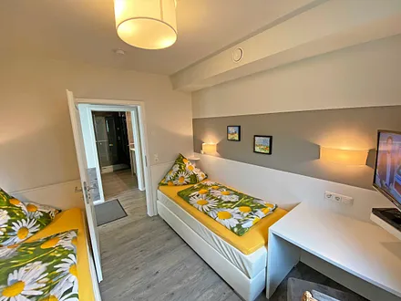 Schlafzimmer mit 2 Boxspringbetten (0,90 m x 2,00 m), Kleiderschrank, Schreibtisch mit Stuhl und TV 