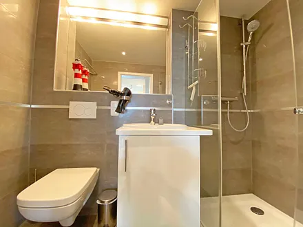 großes Badezimmer mit Fenster, Waschtisch,Wandspiegel, ebenerdiger Regendusche,Wellnesswanne, WC,Haartrockner,Handtuchtrockner,Kosmetikspiegel sowie wohnungseigene Sauna mit Bio-Ofen und LED-Farblicht