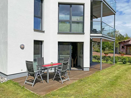 Terrasse (Süd-Ost, Blick zur Strandpromenade) mit Sitzgarnitur und Sonnenschirm 