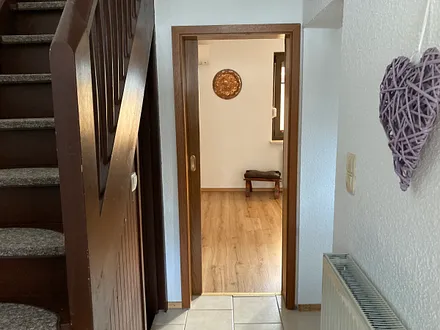 Eingang ,Treppe zum OG, Wohnzimmer, rechts zur Küche