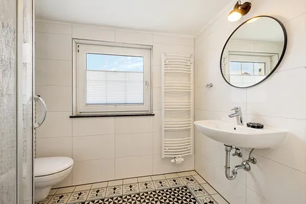 ... Fenster, Handtuchtrockner und Spiegel.