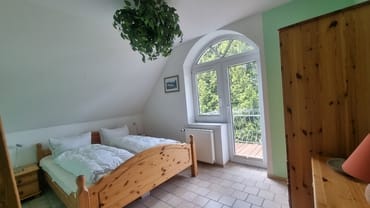 Schlafzimmer mit Balkonzugang und Gartenblick