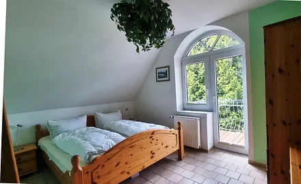 Schlafzimmer mit Balkonzugang und Gartenblick