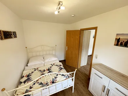 Schlafzimmer mit Doppelbett (1,40 m x 2,00 m), Sideboard, Sessel und Stehlampe (über das Elternschlafzimmer erreichbar)