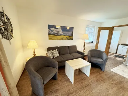 Wohnbereich mit Couch, Couchtisch, Flachbild – TV