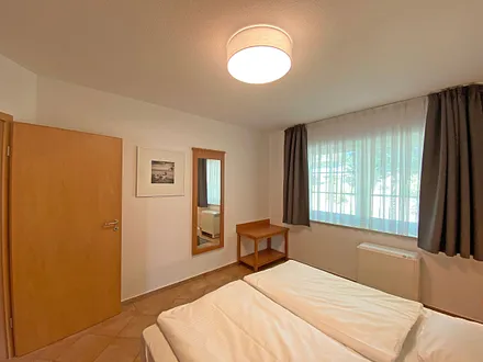 Schlafzimmer mit Doppelbett (1,80 m x 2,00 m), Nachtischablagen und Kleiderschrank