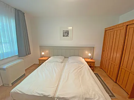 Schlafzimmer mit Doppelbett (1,80 m x 2,00 m), Nachtischablagen und Kleiderschrank