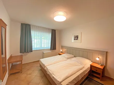 Schlafzimmer mit Doppelbett (1,80 m x 2,00 m), Nachtischablagen und Kleiderschrank