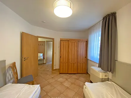 Schlafzimmer mit 2 Einzelbetten (0,90 m x 2,00 m) - auch als Doppelbett stellbar, Nachttischablagen und Kleiderschrank