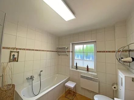 Tageslichtbad mit Badewanne, separater Dusche, Waschtisch, Fön und WC