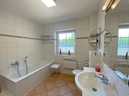 Tageslichtbad mit Badewanne, separater Dusche, Waschtisch, Fön und WC