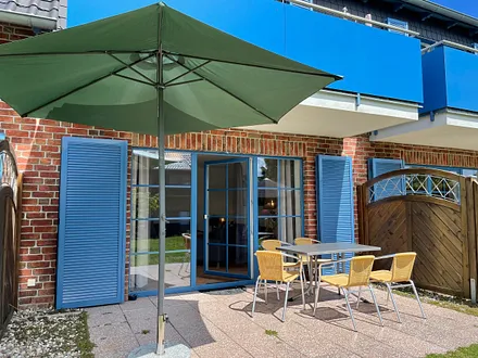 große, bestuhlte Terrasse (West) mit Sonnenschirm