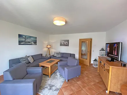 Wohnbereich mit Massivmöbeln, Stehlampe, zwei Sessel, zwei Couchen, 42 Zoll LCD-TV und ein CD/ Blu-Ray-Player