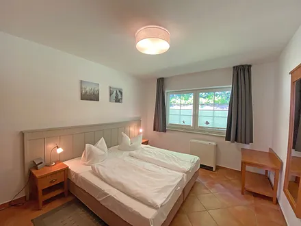 Schlafzimmer mit Doppelbett (1,80 m x 2,00 m), Nachtischablagen und Kleiderschrank 