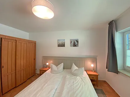 Schlafzimmer mit Doppelbett (1,80 m x 2,00 m), Nachtischablagen und Kleiderschrank 