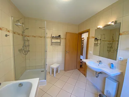 Tageslichtbad mit Badewanne, separater Dusche, großen Waschtisch, Fön und WC 