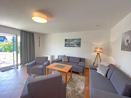 Wohnbereich mit Massivmöbeln, Stehlampe, zwei Sessel, zwei Couchen, 42 Zoll LCD-TV und ein CD/ Blu-Ray-Player