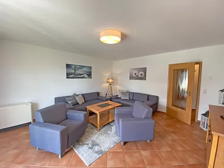 Wohnbereich mit Massivmöbeln, Stehlampe, zwei Sessel, zwei Couchen, 42 Zoll LCD-TV und ein CD/ Blu-Ray-Player