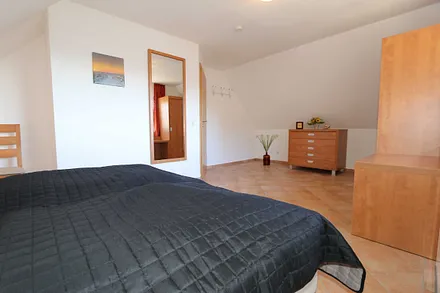 Schlafzimmer mit Doppelbett (1,80 m x 2,00 m), verstellbaren Lattenrosten, Nachttischablagen mit Leselicht und Kleiderschrank 